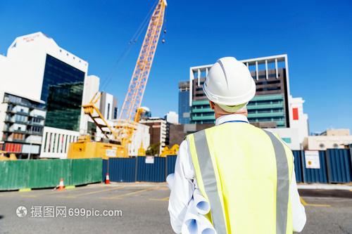 建筑工地的工程师建设者工程师建筑工人施工场景穿着带蓝图的安全背心